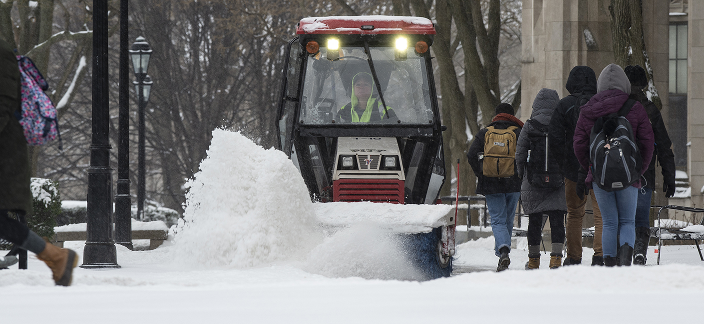 A snowplow shoveling snow on campus