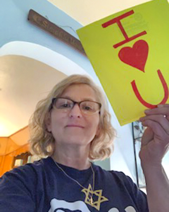 Mary Beth McCulloch, director of UCDC, holds up a sign during a Zoom video chat with families.