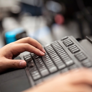 A person typing on a computer keyboard